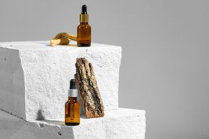 Glass jar of skincare serum on concrete block