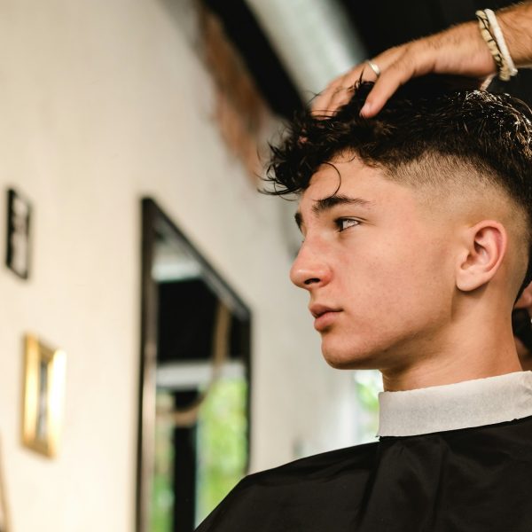 Teenager getting a modern haircut in a vintage barber shop